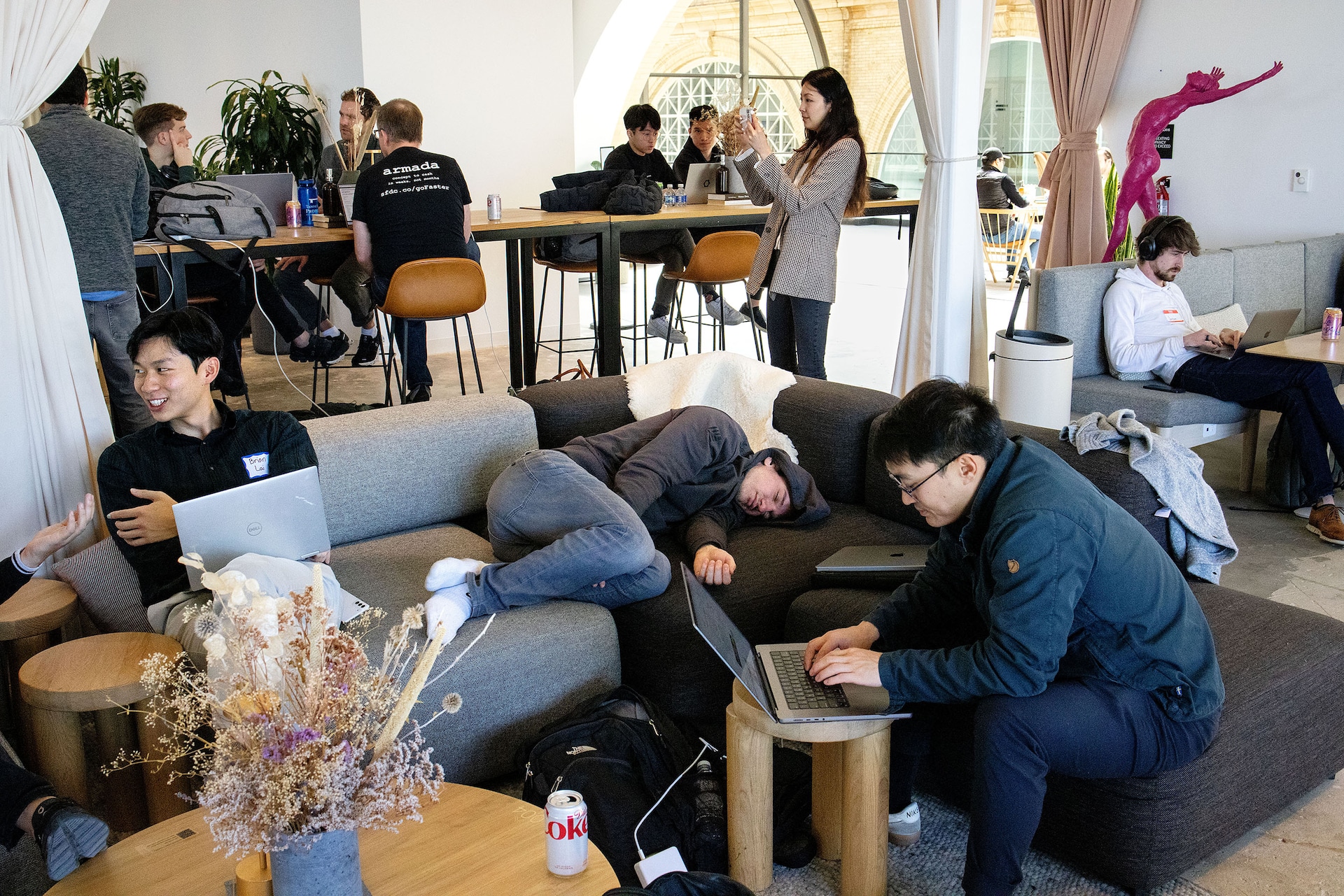 EXTRA: The goal was to use AI to devise solutions to human challenges. // Participants in the “AI For Good” Hackathon work on their laptops as well as take a break to rest during the event at the co-working space Shack15 in the Ferry Building in San Francisco, California on March 25, 2023. The hackathon, organized by Cerebral Valley and Internet Activism, featured 24 hours of coding to build projects, followed by demos. Cerebral Valley is an organization that sprung up to help organize a community around the many people moving to San Francisco to work in AI. They plan co-working days, hackathons, networking meet-ups and other events.