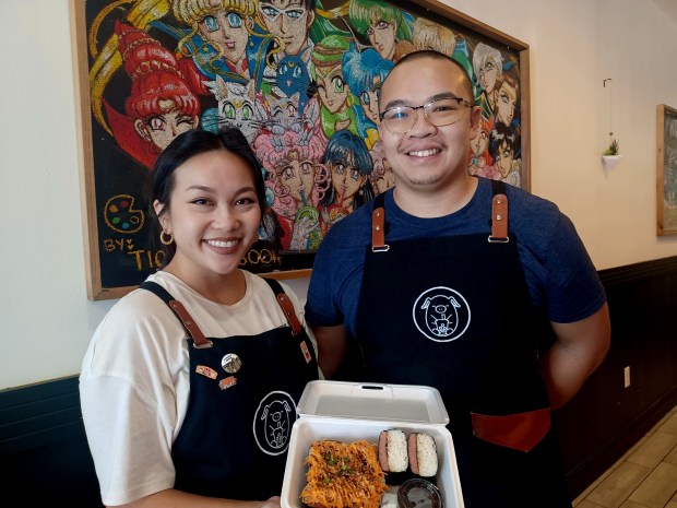 Dang Boba & Musubi House owners Daniel Dang and Raven Nguyen pose in front of original chalk art in their East Orlando shop. (Amy Drew Thompson/Orlan