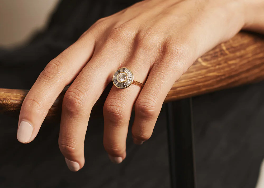 A hand models a fine jewelry ring