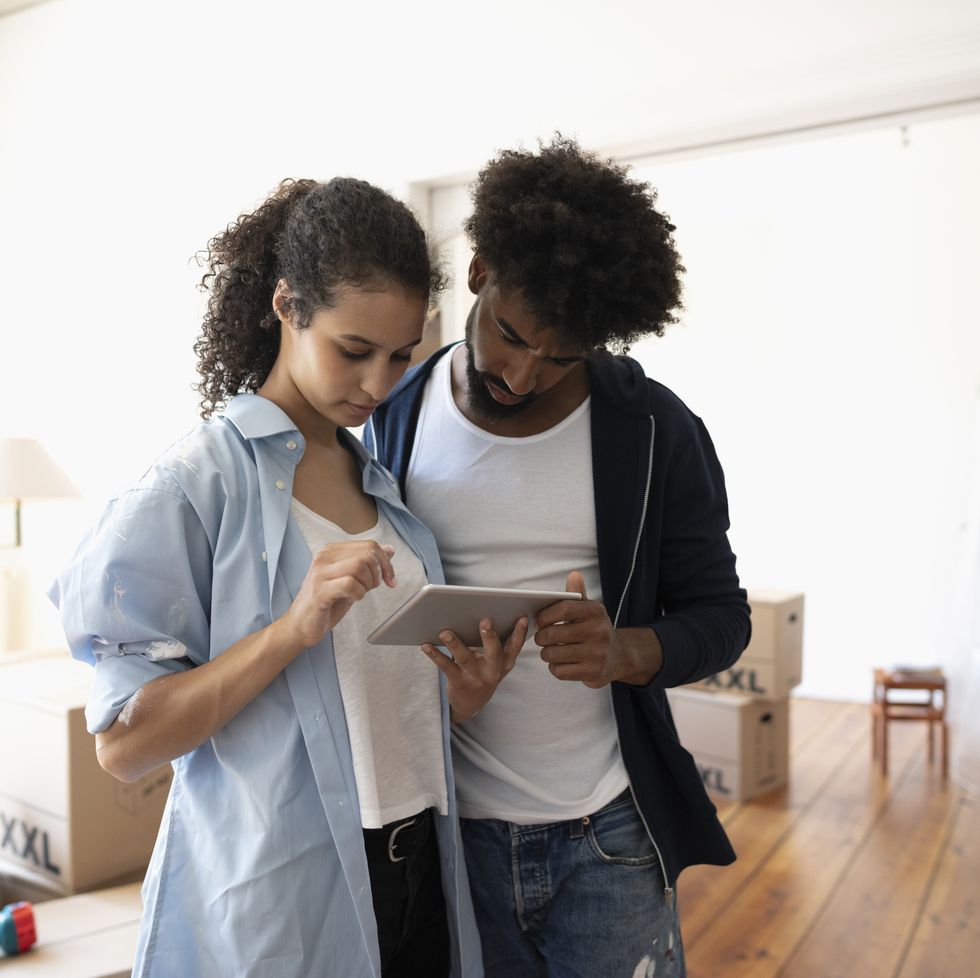 Couple moving into new home, using digital tablet