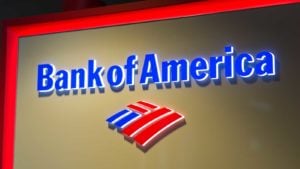 A photo of the Bank of America (BAC) logo in neon red and blue on a tan wall.