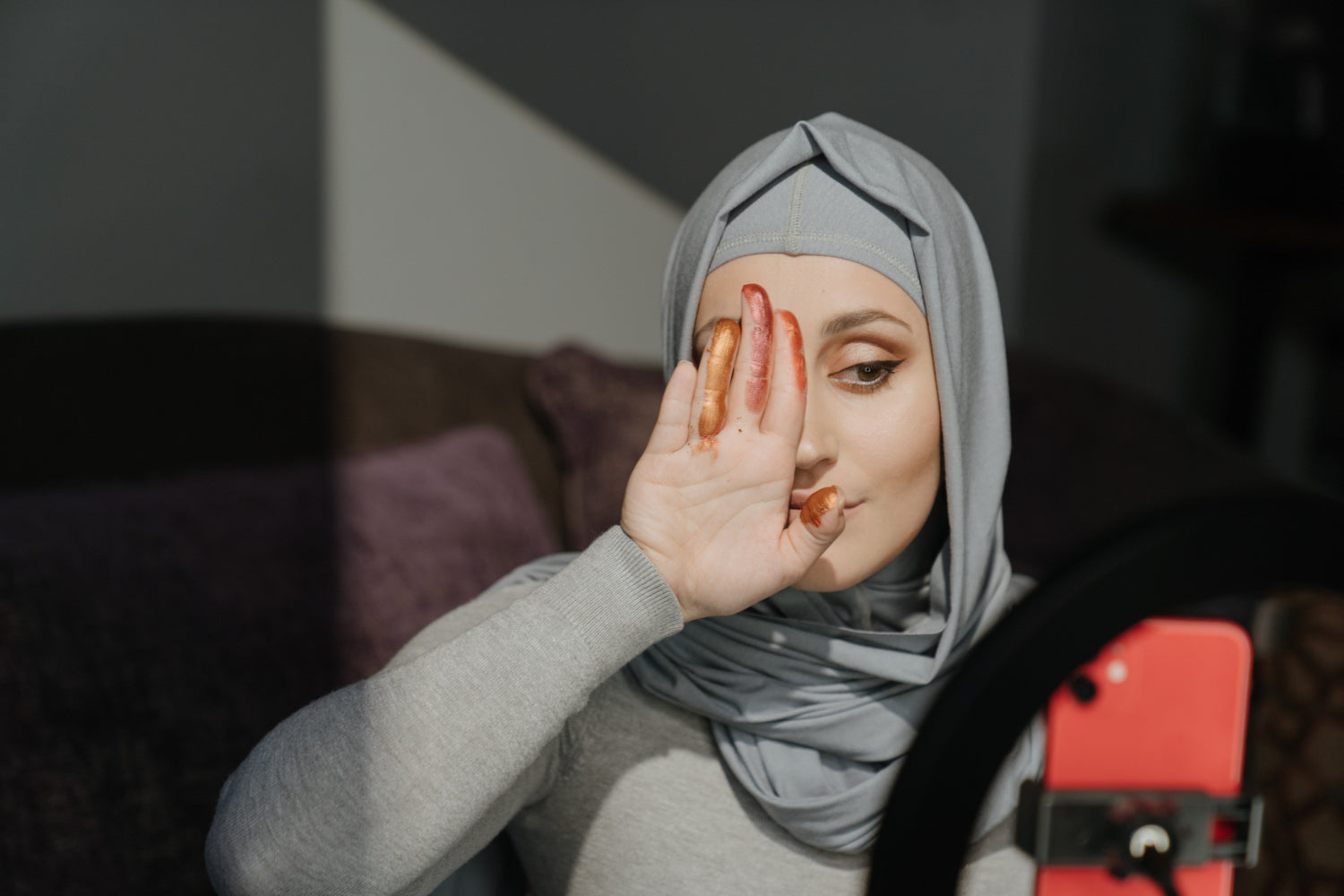 A woman shoots a make up demo using a mobile phone