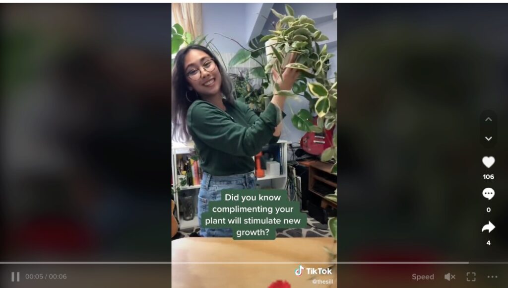 The Sill's tiktok of a woman holding a potted plant and smiling.