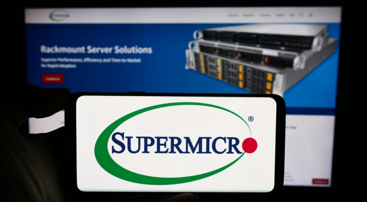 Person holding cellphone with logo of US company Super Micro Computer Inc. (SMCI) (Supermicro) in front of business webpage. Focus on phone display. Unmodified photo.