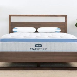 Bear Star Hybrid mattress on a wooden bed frame in a minimalist bedroom.