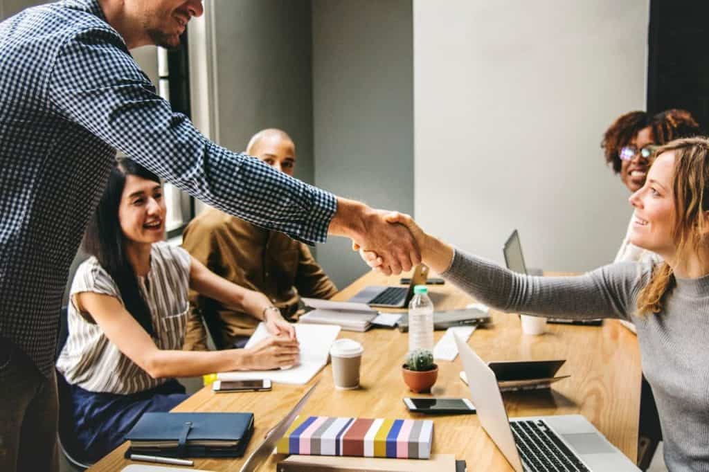 colleagues meet in conference room at office shake hands