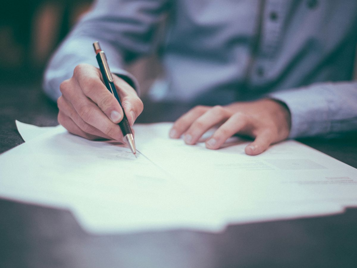 man writing on paper