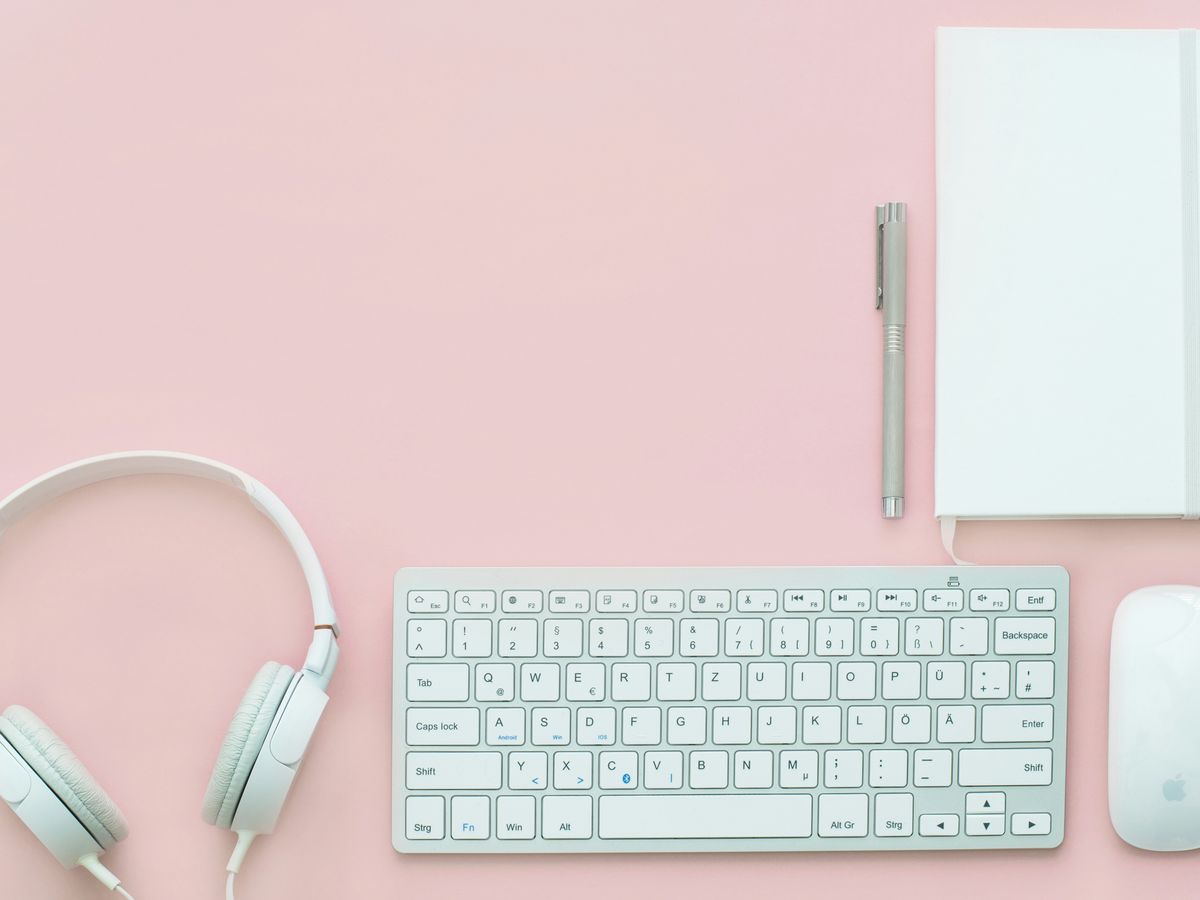 white Apple Magic Mouse beside of Magic Keyboard and headphones