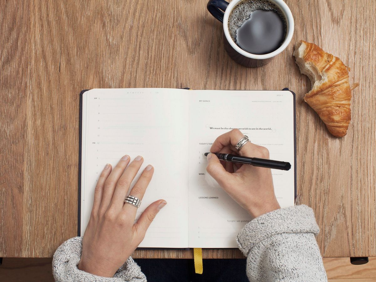 person writing on a book