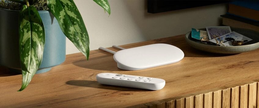 White Google TV Streamer and remote controller on brown table