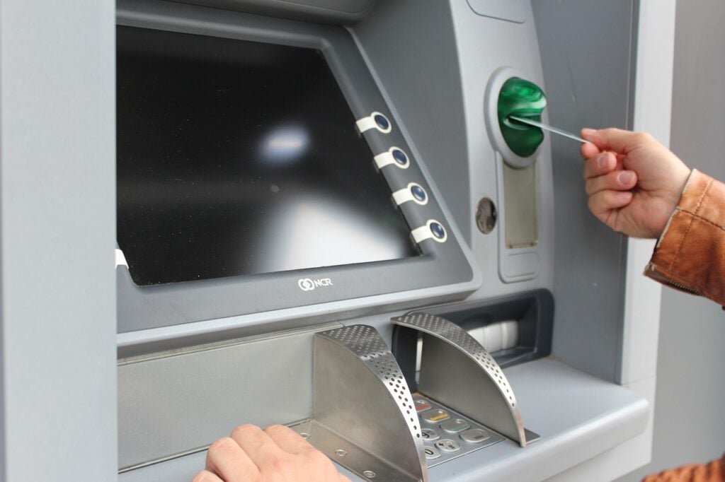 A person inserts a bank card into an ATM.