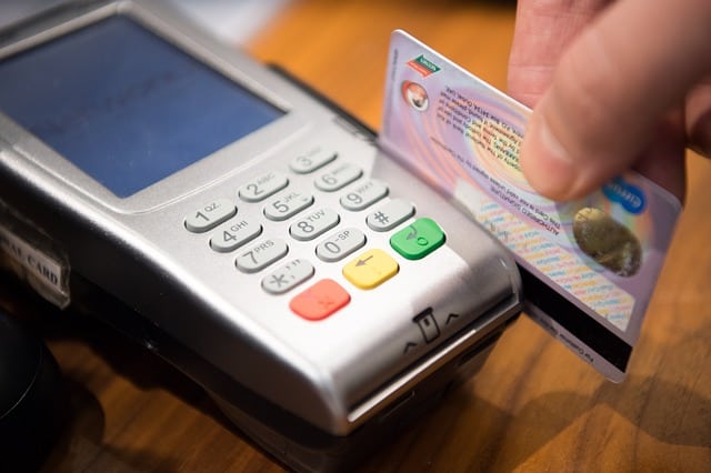 A person is putting a credit card into a machine.