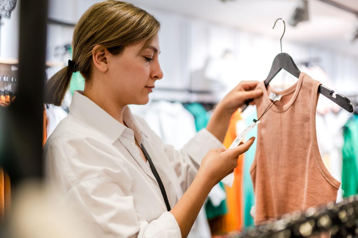 Young woman looking at price tag while shopping