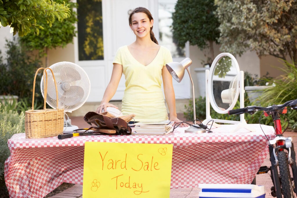 Person standing behind a table with various items and a 