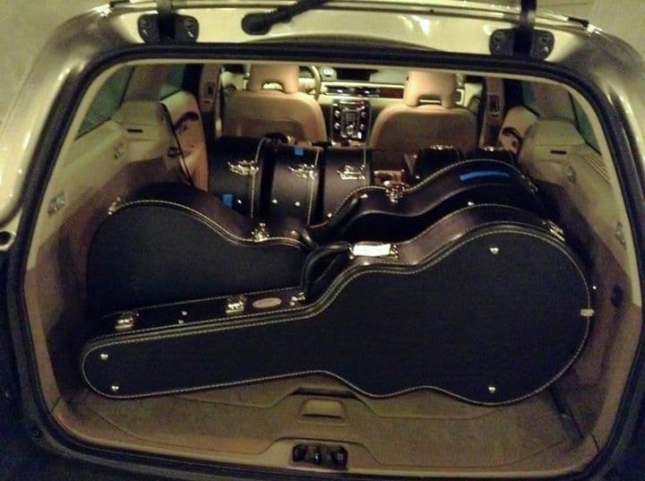 Car trunk loaded with multiple guitar cases.