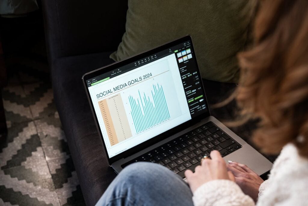 Person viewing a social media goals presentation on a laptop, displaying a bar chart labeled 