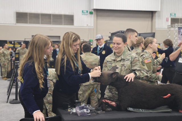 Visitors of the Army Interactive Zone gather around the veterinarian display which included a canine mannequin in need of treatment as part of the National Future Farmers of America convention at Indianapolis, Indiana Oct. 23-25 2024. Fort Knox...