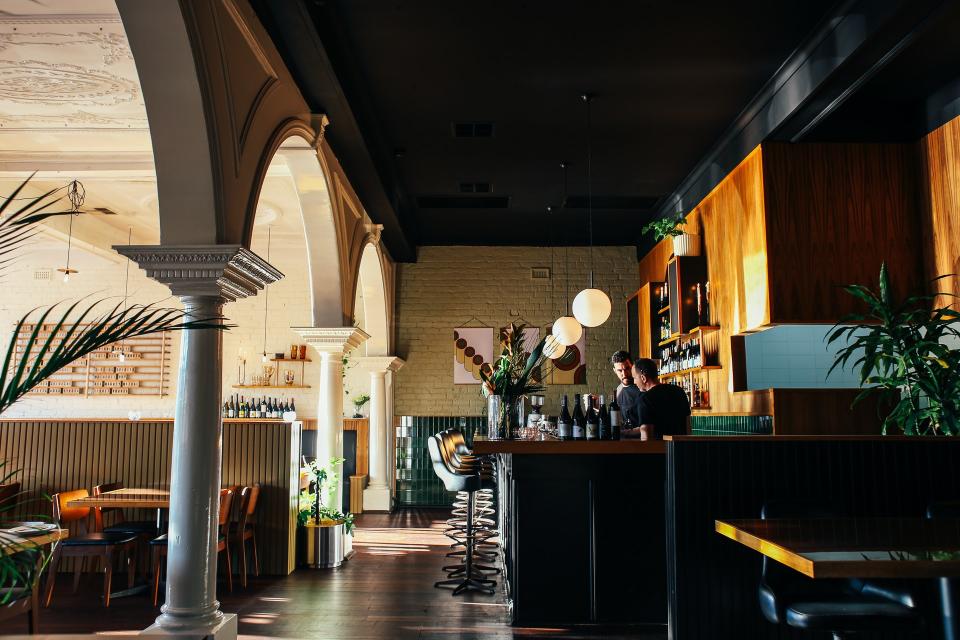 Large grand restaurant interior with two managers at the bar