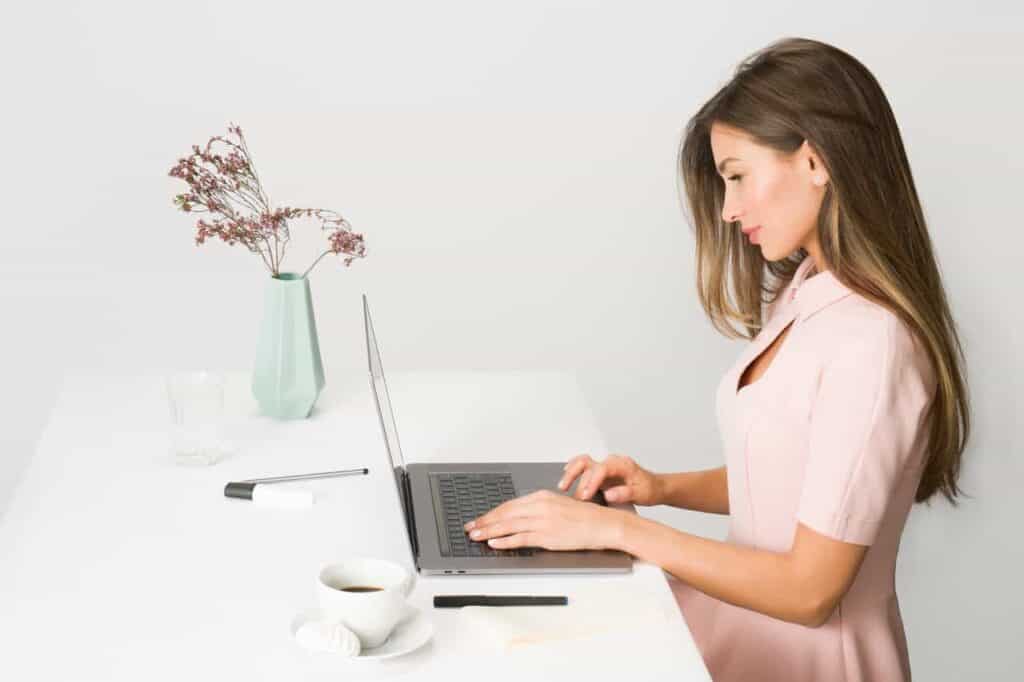 woman-in-pink-dress-using-laptop-computer-working