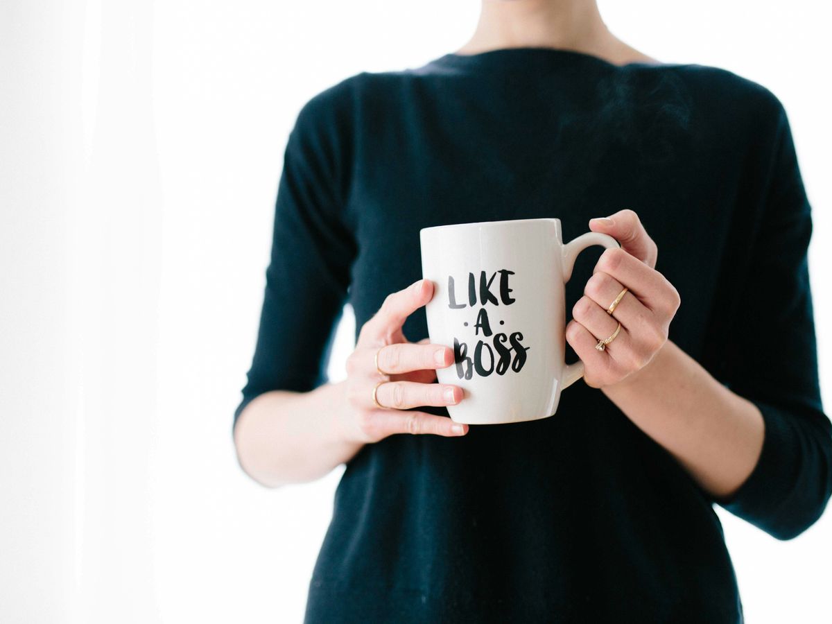 woman holding white mug while standing